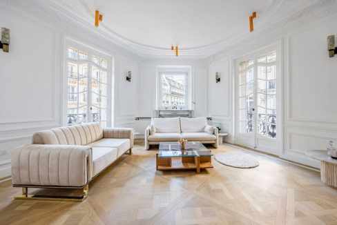 Bright living room with large windows, white walls, and stylish furniture, showcasing a spacious and.