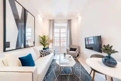 Bright living room featuring contemporary furniture and large windows.