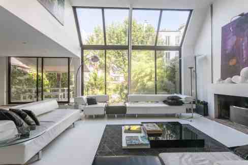 Spacious modern living room with large windows and contemporary furniture.