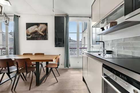 Contemporary kitchen with dining area and large window in Vosges Gallery Living.
