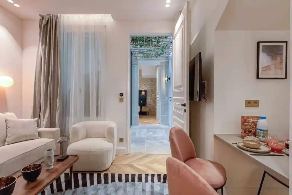 Modern living room with cozy seating and natural light in a serviced apartment.