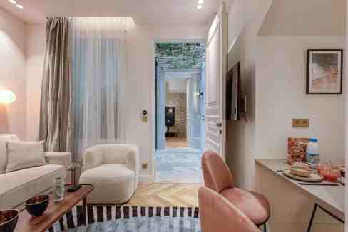 Modern living room with cozy seating and natural light in a serviced apartment.