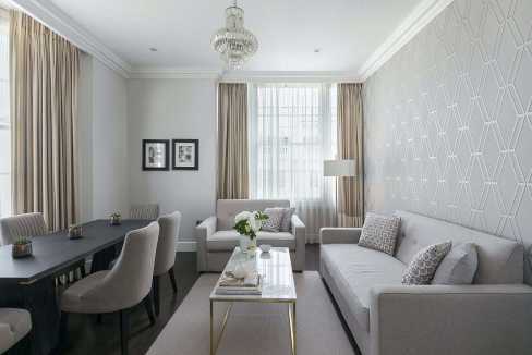 Modern living room with sofas, dining table, and large window in Bayswater.