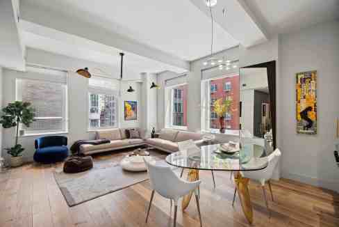 Spacious living room featuring large windows, modern furniture, and vibrant artwork for a stylish ur.