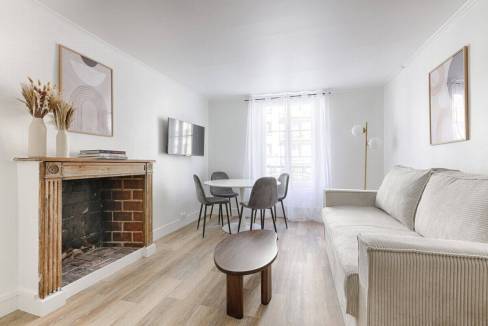 Bright and airy living room featuring a cozy fireplace, minimalist decor, and large windows allowing.