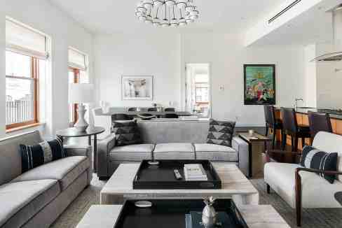 Bright and spacious modern living room with large windows and contemporary furniture.