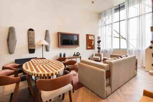 Modern living room with sofa, dining table, and large windows in Luxembourg.