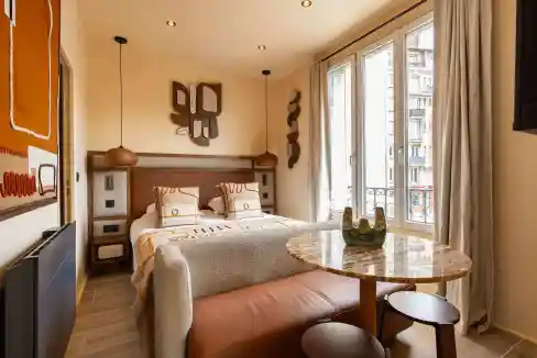 Bright living room with large windows, cozy seating, and contemporary decor.
