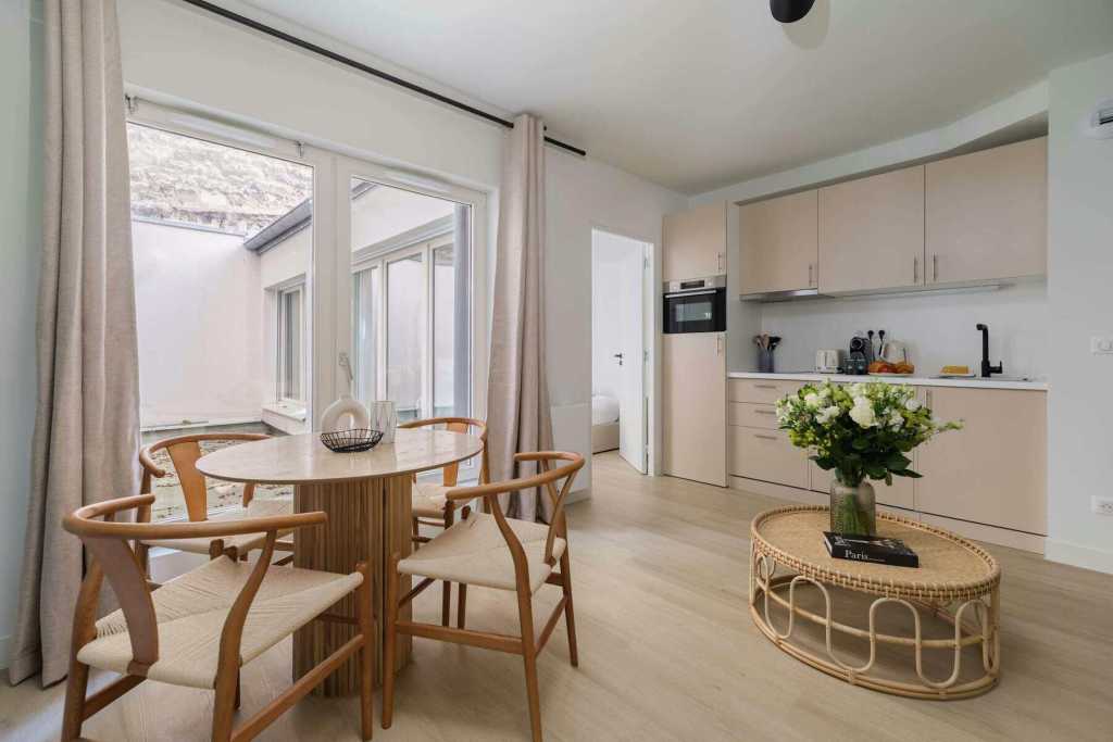 Modern apartment interior with dining area and kitchen in Batignolles Lumière Suite.