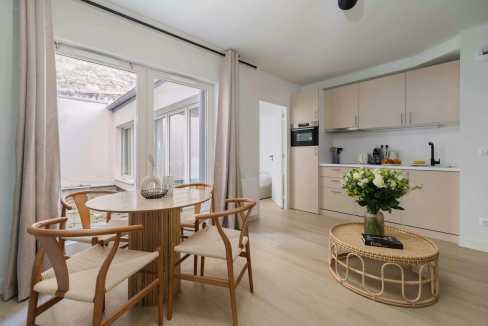 Modern apartment interior with dining area and kitchen in Batignolles Lumière Suite.