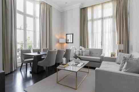 Bright and stylish living room with large windows and modern furniture.