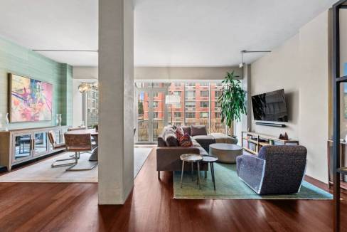 Contemporary living room with large windows, stylish furniture, and vibrant decor.