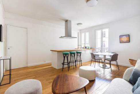 Bright, modern living space with open kitchen and seating area in Paris.