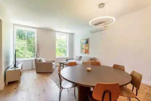 Bright living room featuring large windows, contemporary furniture, and minimalist decor.