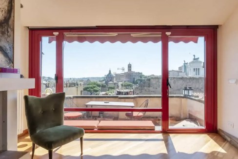 Bright living space with large glass doors overlooking historic city skyline.