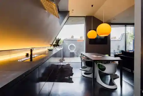 Contemporary apartment interior with dining area and large windows.