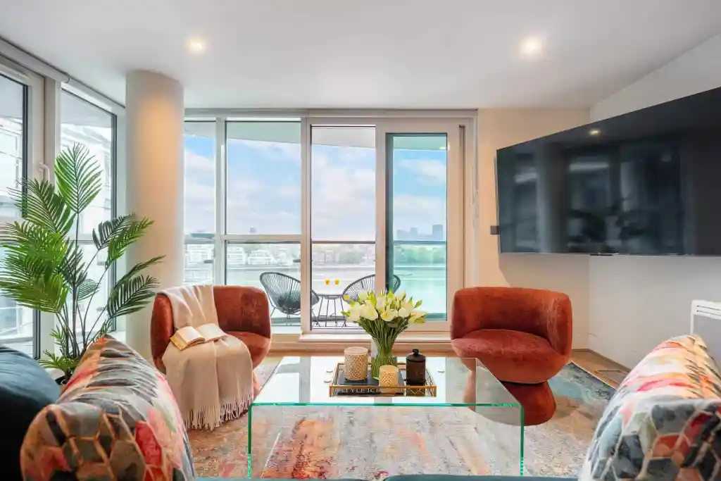 Bright living room with large windows overlooking the city skyline and water, featuring contemporary.