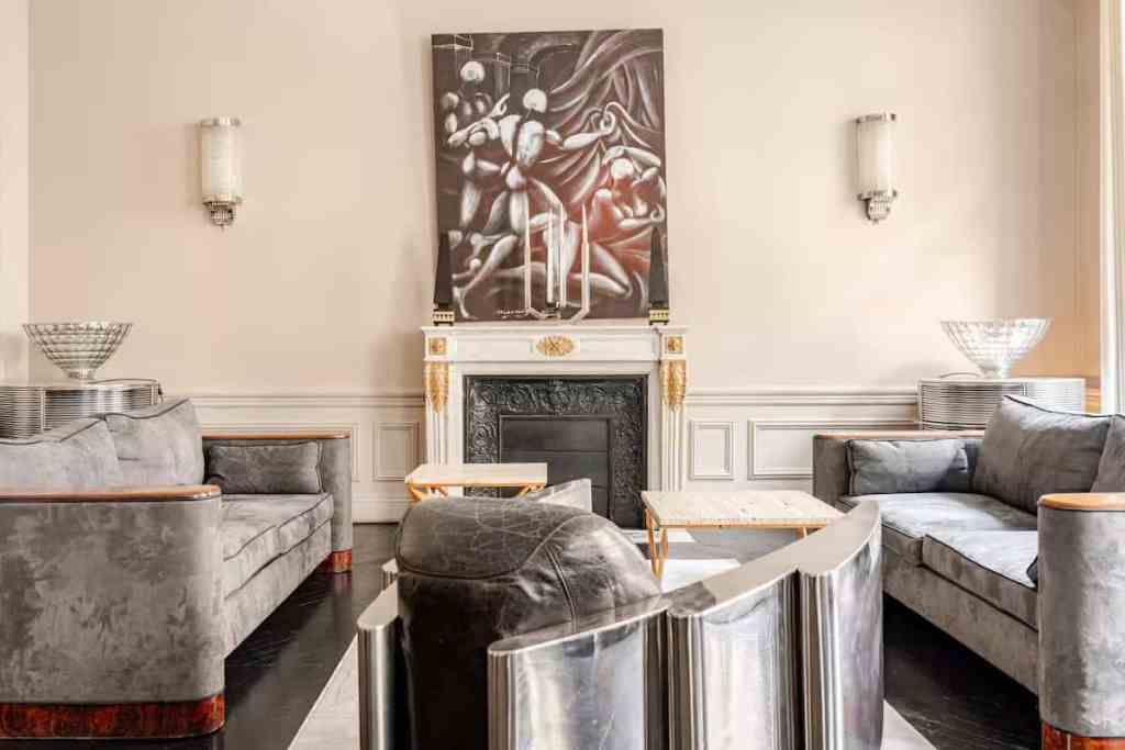Stylish living room with fireplace, modern art, and plush sofas.