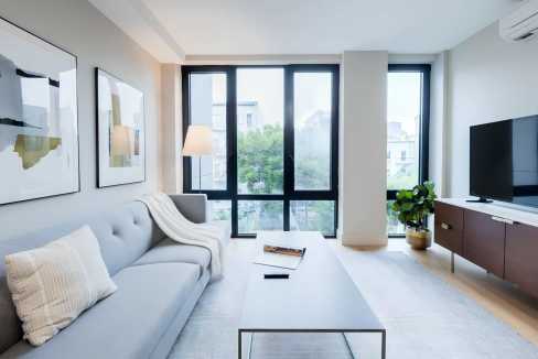 Bright living room with large windows, contemporary furniture, and natural light.