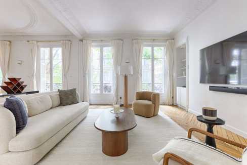 Bright living room with large windows, white walls, and modern furniture.