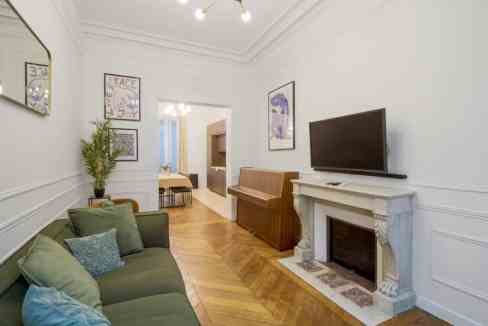 Stylish living room with fireplace, sofa, and artwork in a serviced apartment.