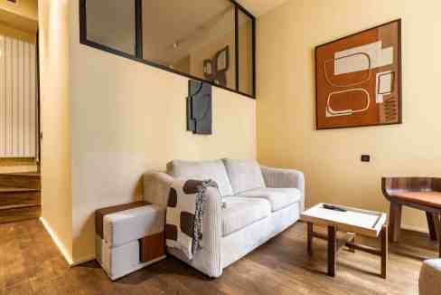 Contemporary living room with beige sofa and wooden accents.