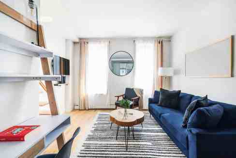 Bright and modern living room with sofa, armchair, and decorative accents.
