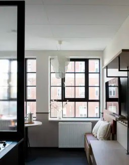 Bright modern apartment interior with large windows and minimalist decor.