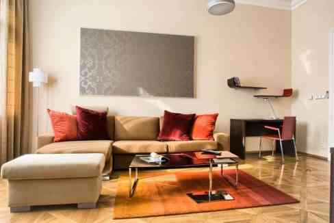 Modern living room with beige sofa, colorful cushions, and wooden flooring.
