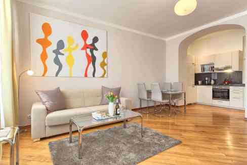 Modern living room with abstract art, sofa, and dining area in a serviced apartment.