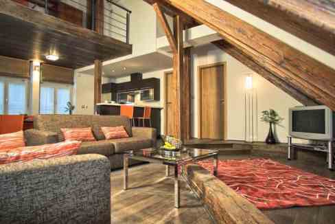 Modern serviced apartment living room with wooden beams and cozy furniture.