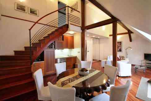 Elegant open-plan living and dining area with wooden accents and modern furnishings.
