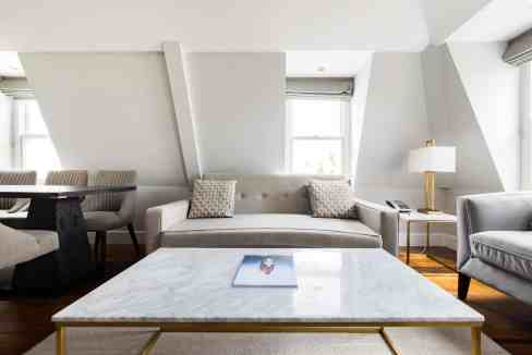 Stylish living room with sofa, armchair, and marble coffee table in Bayswater Loft.