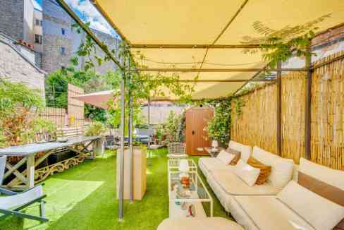 Outdoor garden lounge with seating, shade, and greenery in Trocadéro Garden.