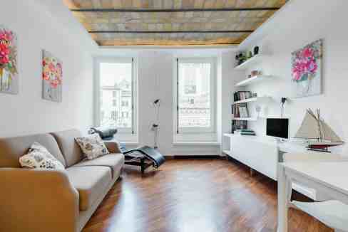 Bright living room with contemporary art, white walls, and natural light. Cozy seating area with dec.