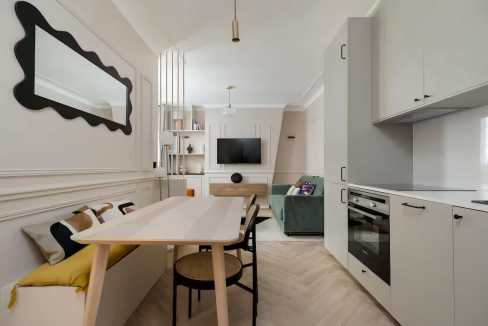 Bright, modern living space with dining area and kitchen in a serviced apartment.