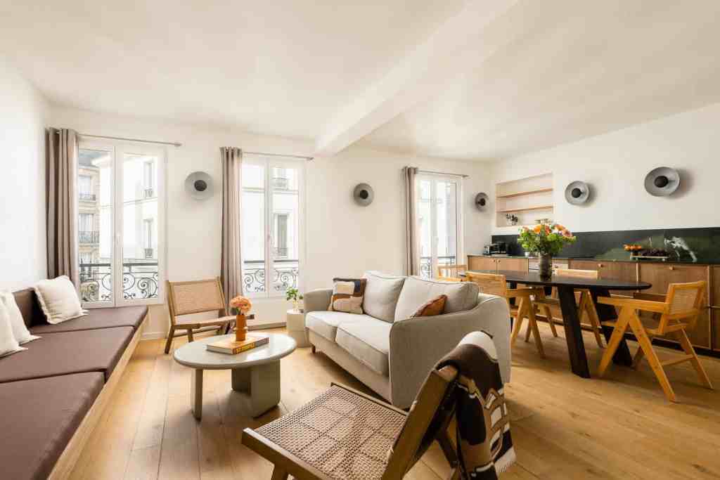 Bright living room with large windows, modern furniture, and wooden accents.