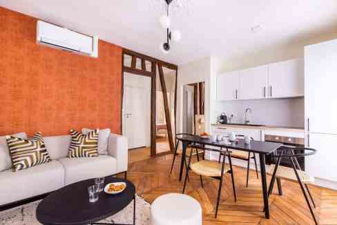 Contemporary living space with sofa, dining area, and kitchen in a serviced apartment.