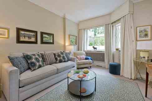 Stylish living room with sofa, armchair, and large window in Holland Park.
