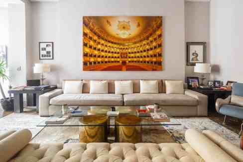Elegant living room with large, ornate theater-style artwork on the wall, modern furniture, and styl.
