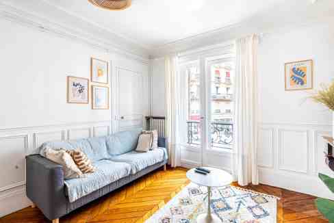 Bright living room with large windows and elegant decor.