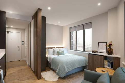 Contemporary bedroom in serviced apartment with large window and minimalist decor.
