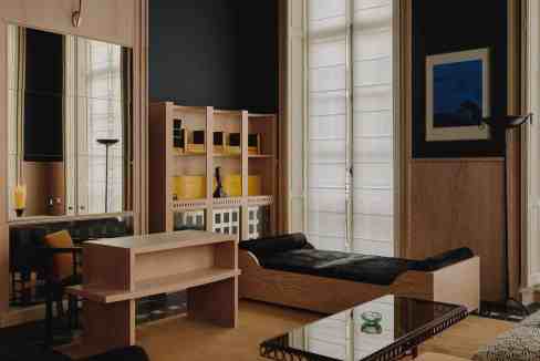 Modern serviced apartment interior with minimalist furniture and large windows.