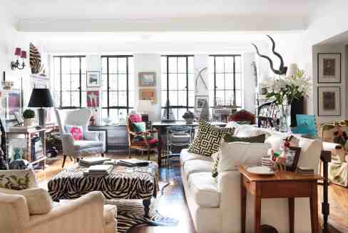 Bright eclectic living room with colorful furniture, artwork, and decorative accessories in a spacio.