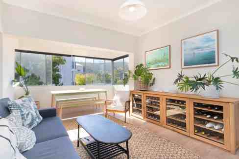 Indoor living room with large window, cozy seating, and decorative plants.