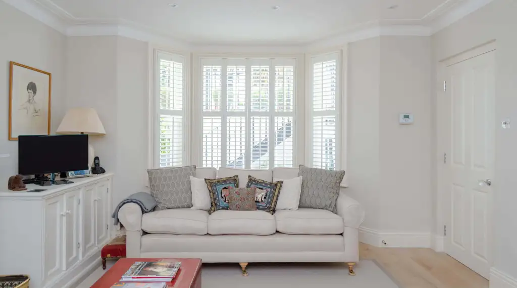 Bright living room with large bay windows and elegant decor.