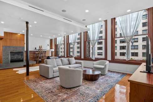 Spacious living room featuring large windows, contemporary furniture, and a cozy atmosphere in a hig.