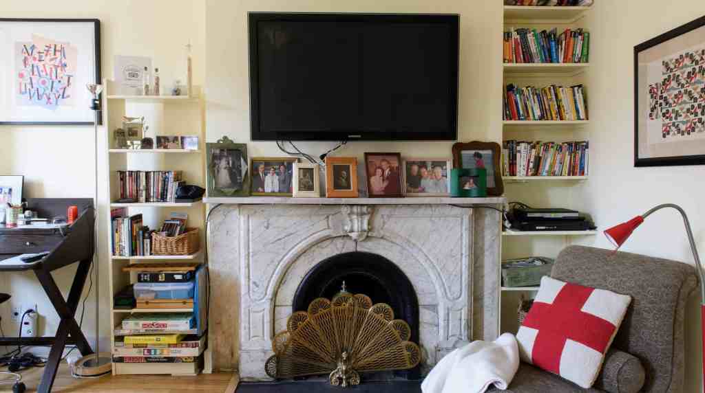 Comfortable living room featuring a fireplace, bookshelves, and cozy seating area with decorative cu.