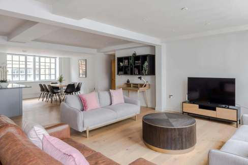 Spacious living room with contemporary furniture and large windows.