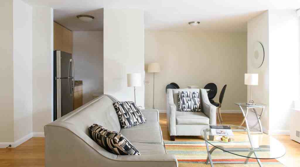 Living room with beige sofas, black and white pillows, and contemporary furniture.